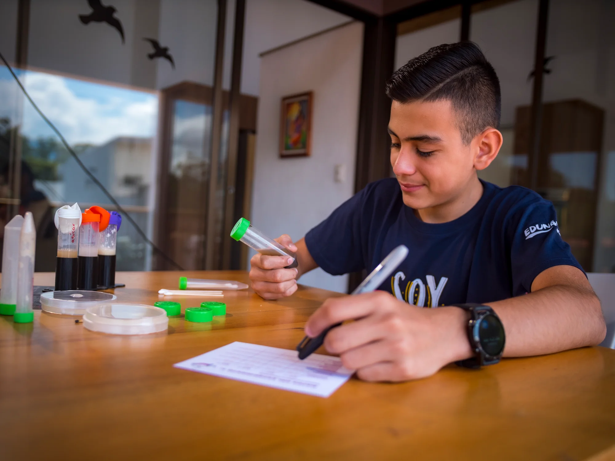 Beneficiario de Edunámica completando la hoja de registro de su experimento científico