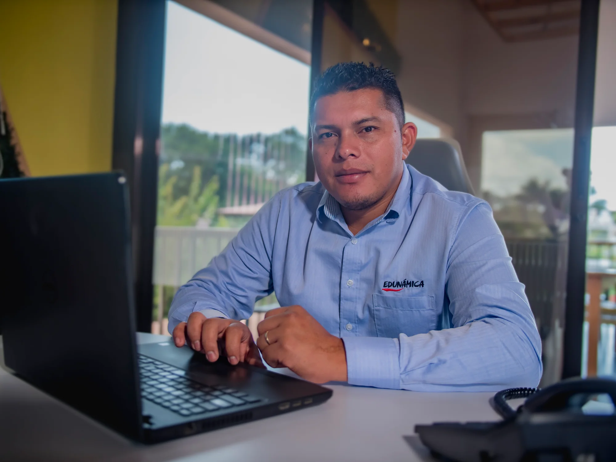 Retrato institucional de un colaborador de Edunámica trabajando en su laptop
