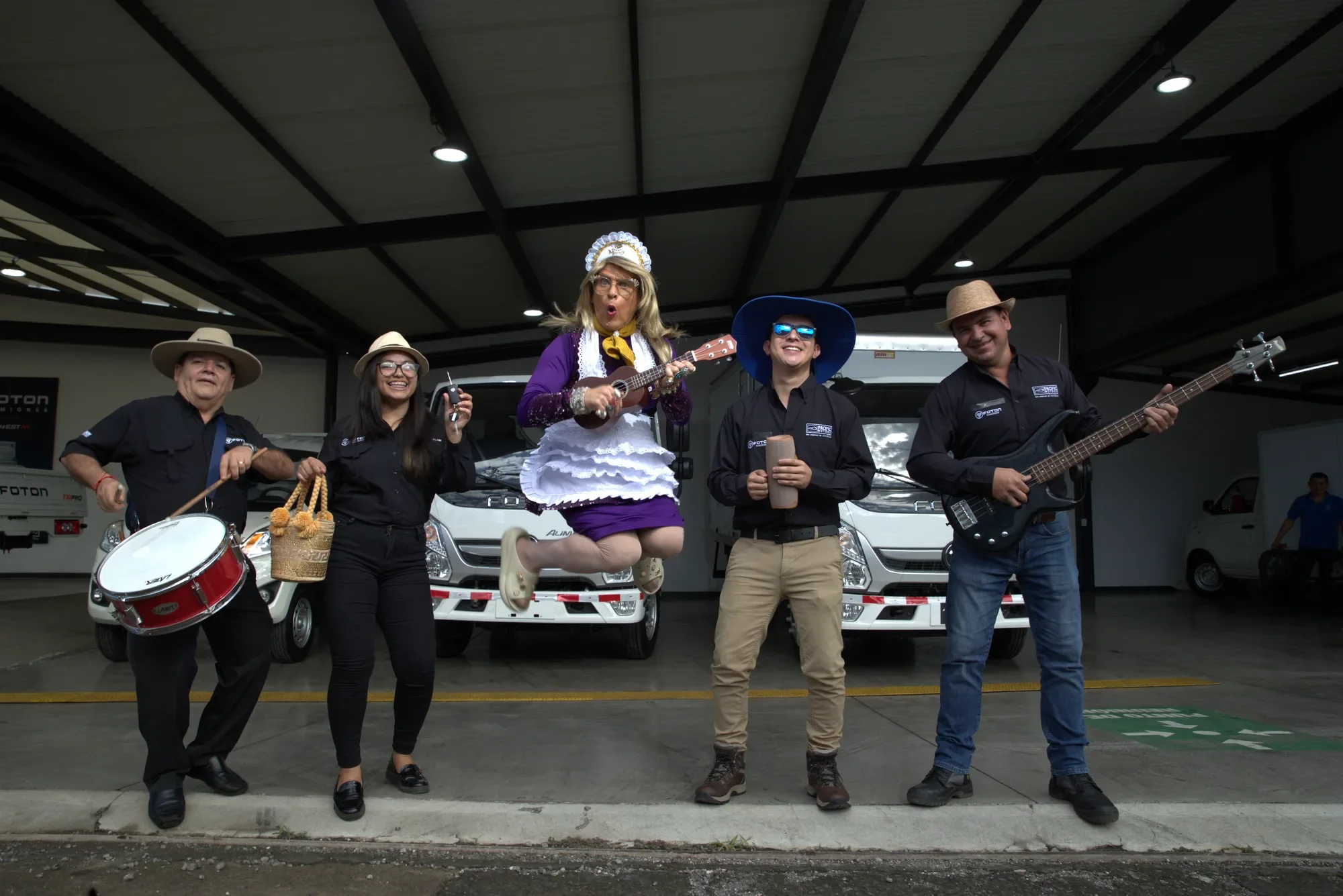 Doña Merry salta con un ukulele frente a camiones Foton Aumark, junto al equipo de Pacific Motors