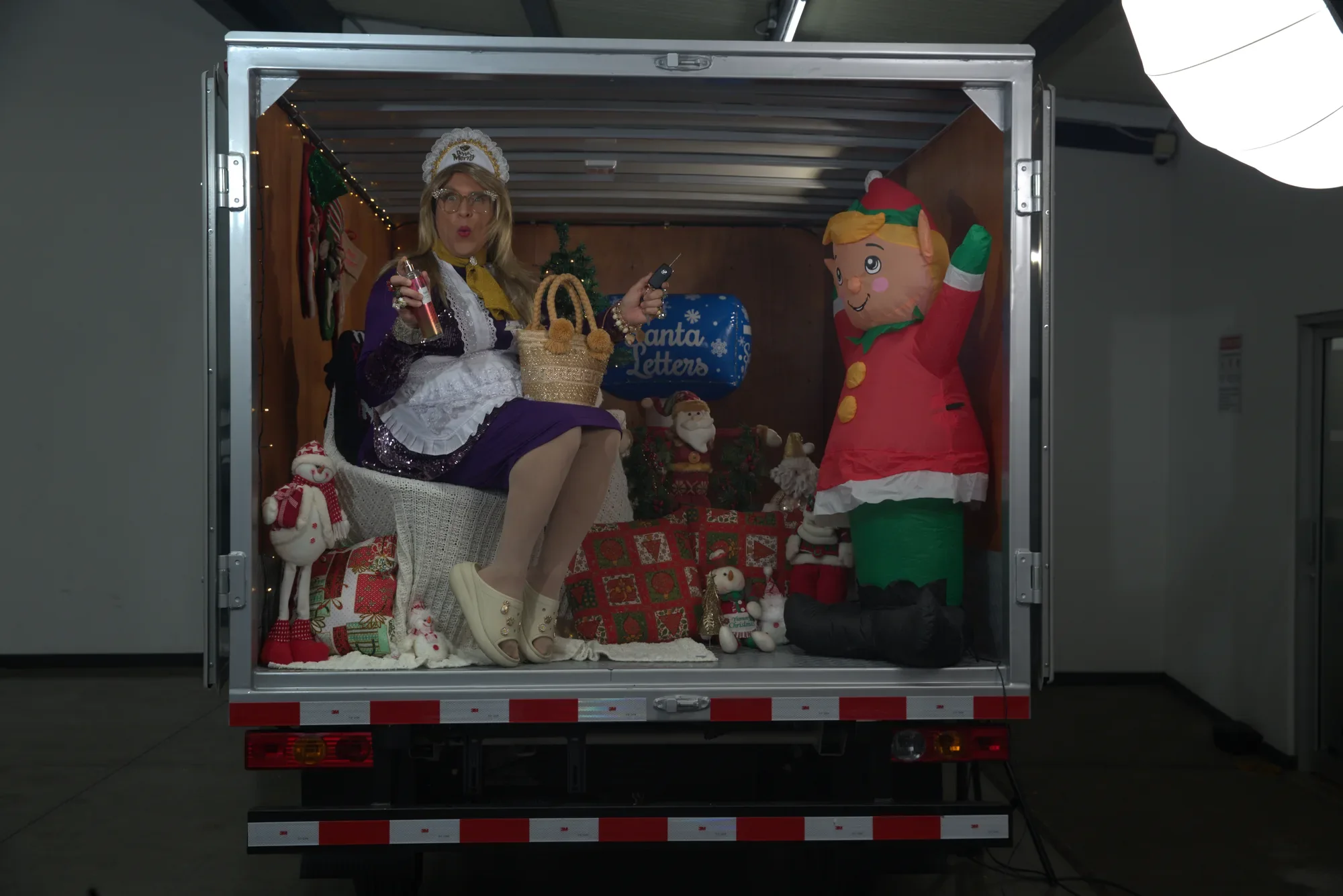 Doña Merry sentada en el furgón de un camión Foton decorado de Navidad