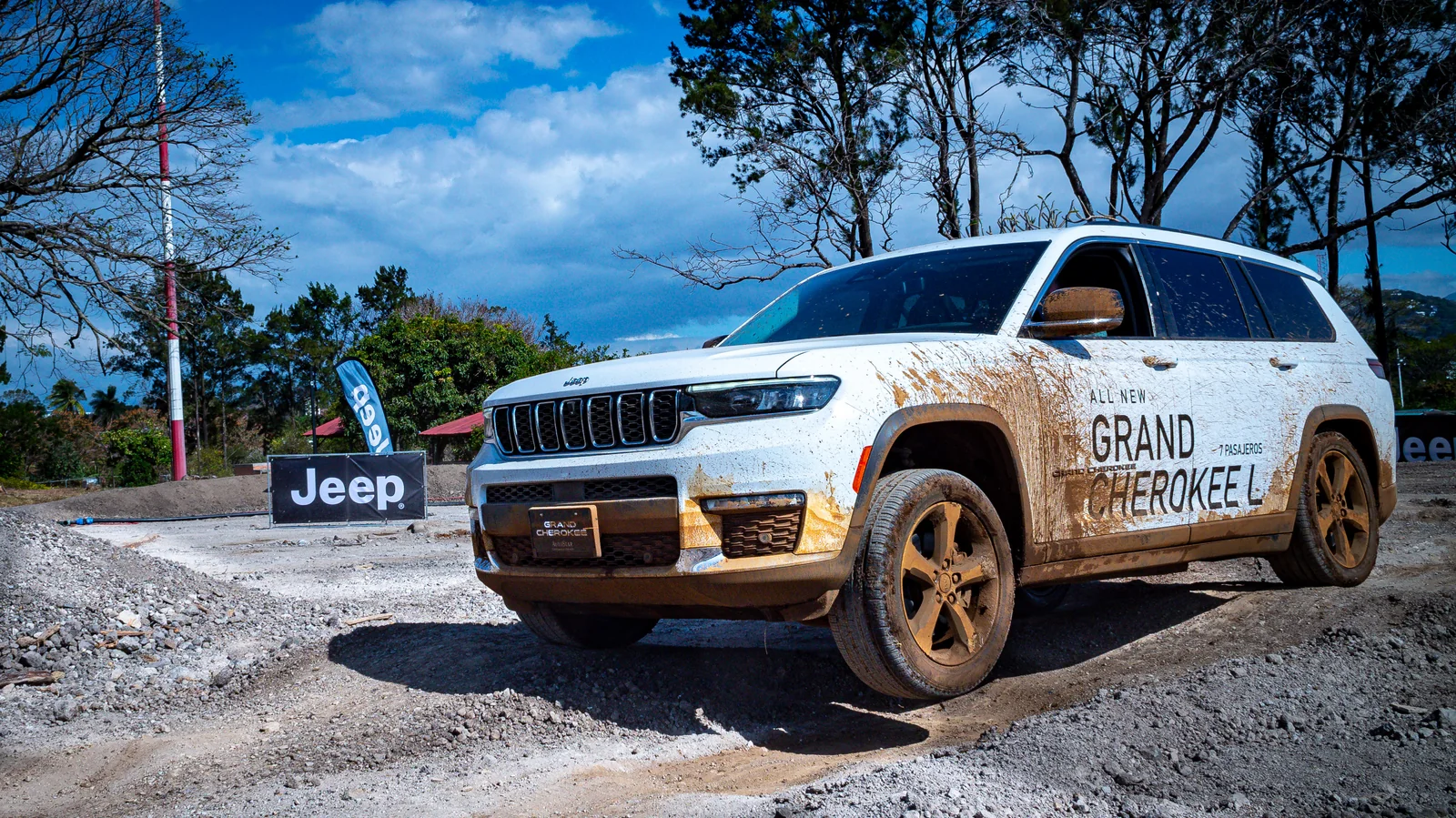Jeep Grand Cherokee L junto al banderín 'All New Grand Cherokee L' bajo cielo dramático — Jeep Costa Rica